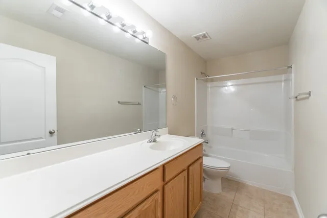 a bathroom with a bathtub shower sink mirror and toilet