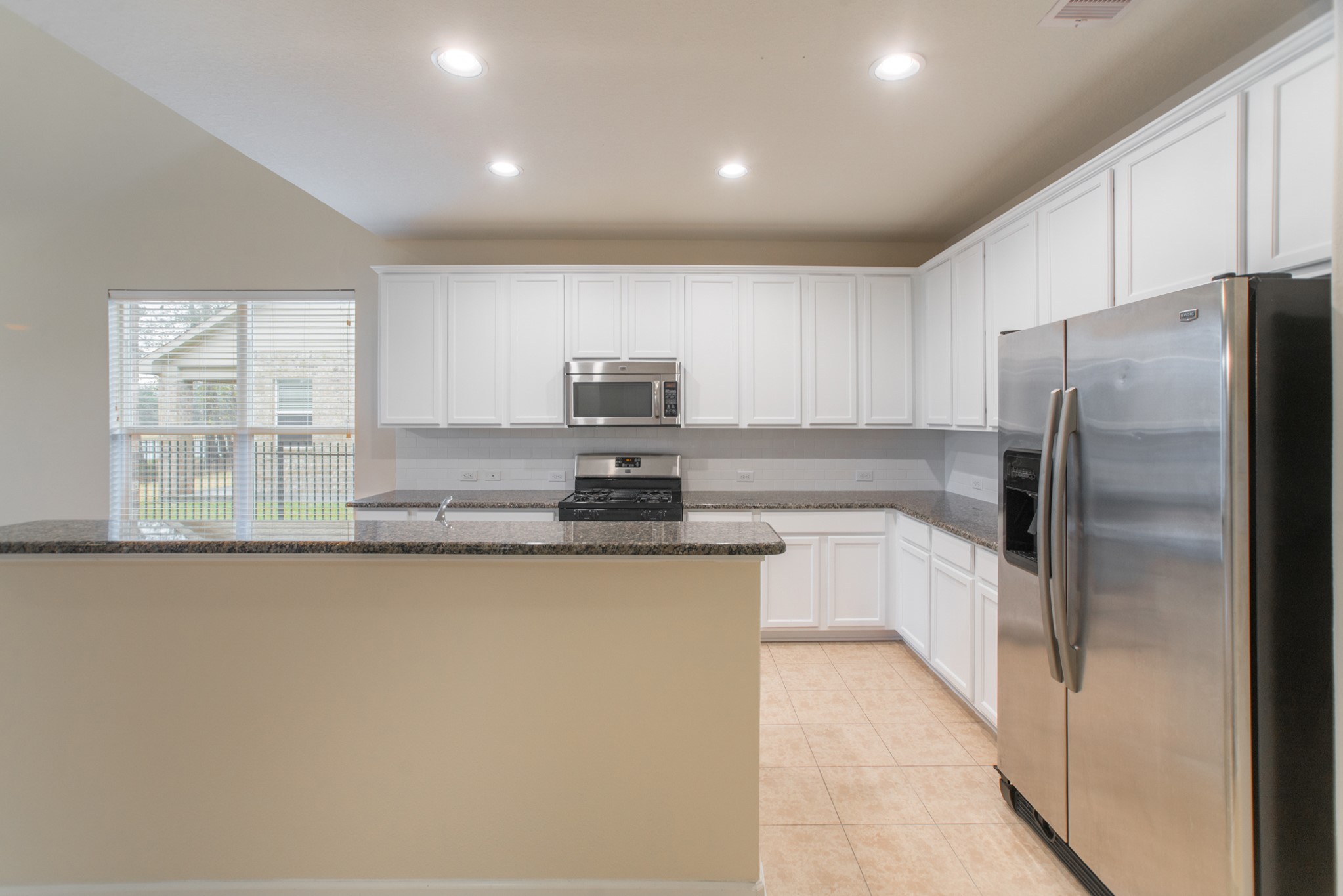 78 East Heritage Mill Circle The Woodlands, TX 77375 - Photo 10 of 50 a kitchen with stainless steel appliances granite countertop a refrigerator a stove and a sink