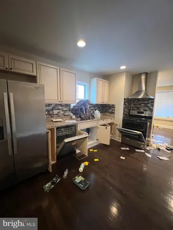 a kitchen with a refrigerator and a stove top oven