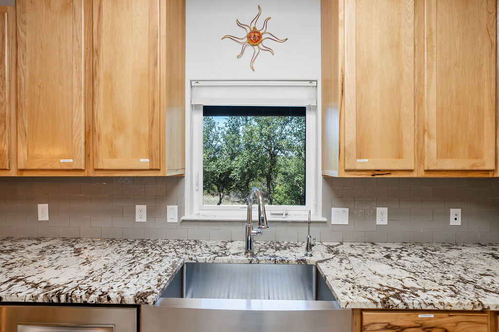 13326 Trautwein Road Austin, TX 78737 - Photo 8 of 38 Kitchen with a sink, backsplash, and light stone counters