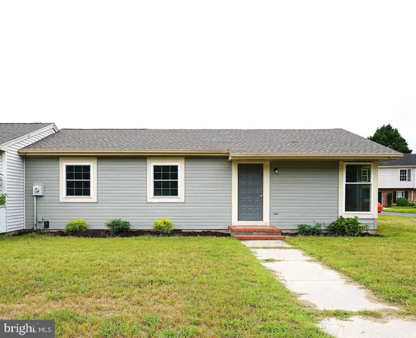 a brick house with a yard potted plants and brick wall