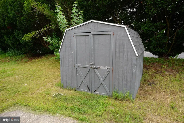 a view of a small barn in the middle of a yard