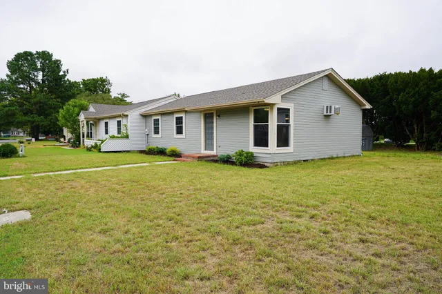 a front view of house with yard and trees around