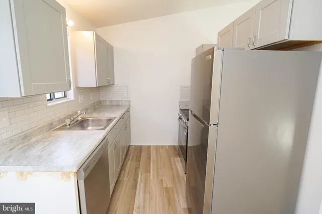 a bathroom with a granite countertop sink and washing machine