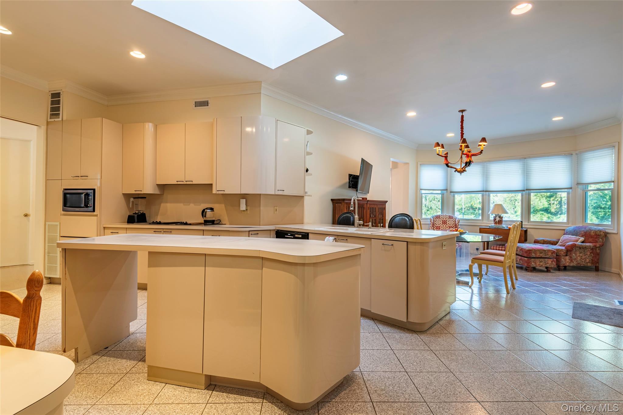 735 Remsens Lane Upper Brookville, NY 11771 - Photo 15 of 44 Kitchen with crown molding, a peninsula, recessed lighting, light countertops, and a skylight