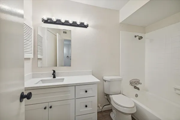 a bathroom with a toilet a sink a mirror and vanity