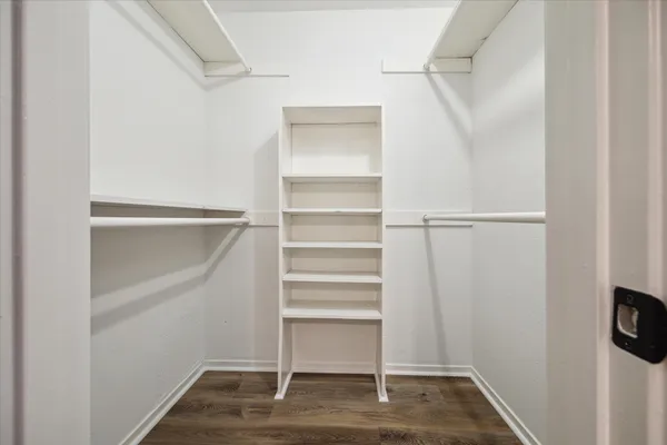 a view of walk in closet with empty racks