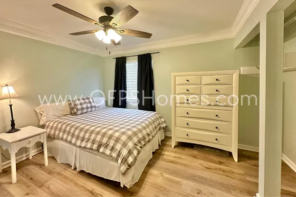 a bedroom with a bed and a ceiling fan