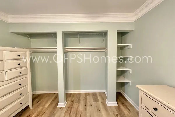 a view of walk in closet with empty racks