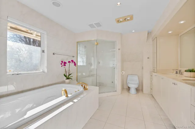 a bathroom with a granite countertop tub a sink and a large mirror