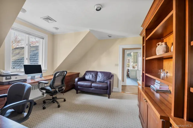 a view of a workspace with furniture and a window