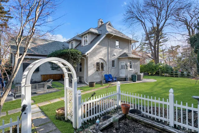 a view of a house with wooden fence next to a yard