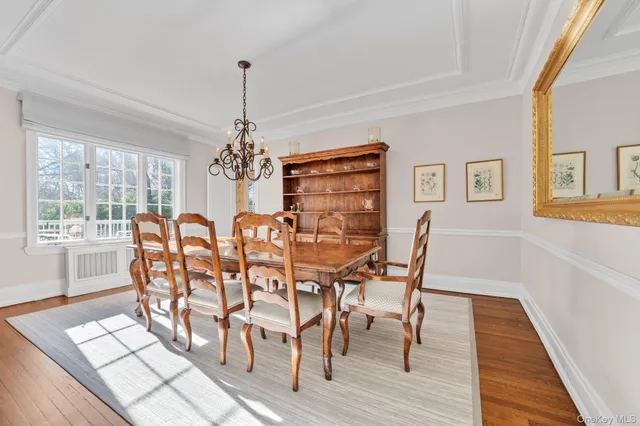 a dining room with furniture window and wooden floor