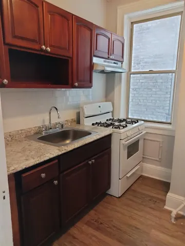 a kitchen with granite countertop wooden cabinets and white appliances