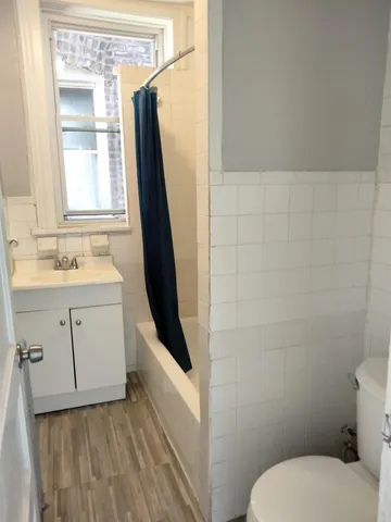 a bathroom with a sink a toilet a mirror and a window