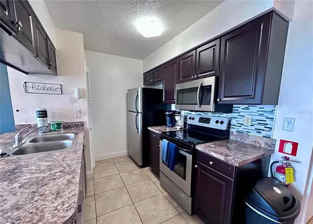 a kitchen with stainless steel appliances granite countertop a stove refrigerator and microwave