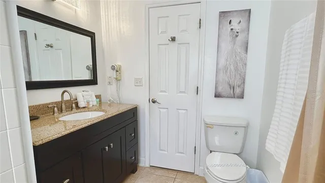 a bathroom with a granite countertop sink toilet a mirror and shower