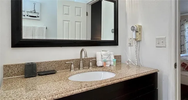a bathroom with a granite countertop sink and a mirror