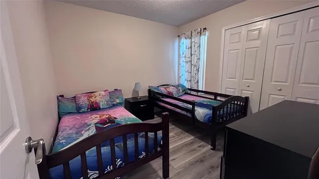 a bedroom with two beds and wooden floor