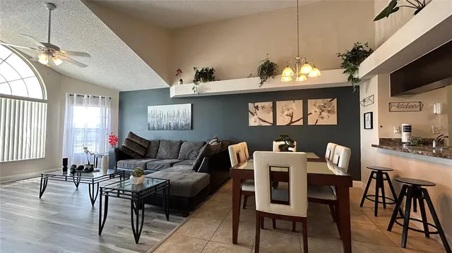 a living room with furniture a flat screen tv and kitchen view