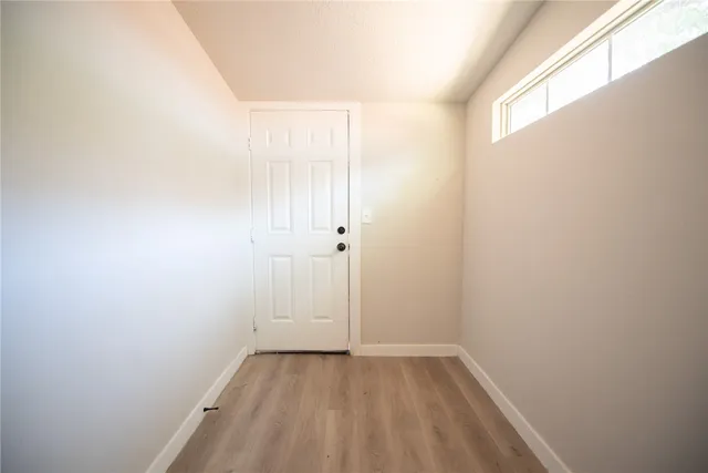 a view of a small space with wooden floor and a window