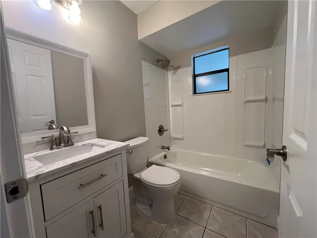 a bathroom with a double vanity sink toilet mirror and bathtub