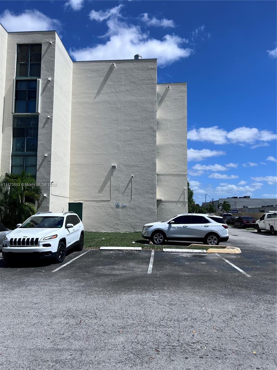 a car parked beside a road next to a building