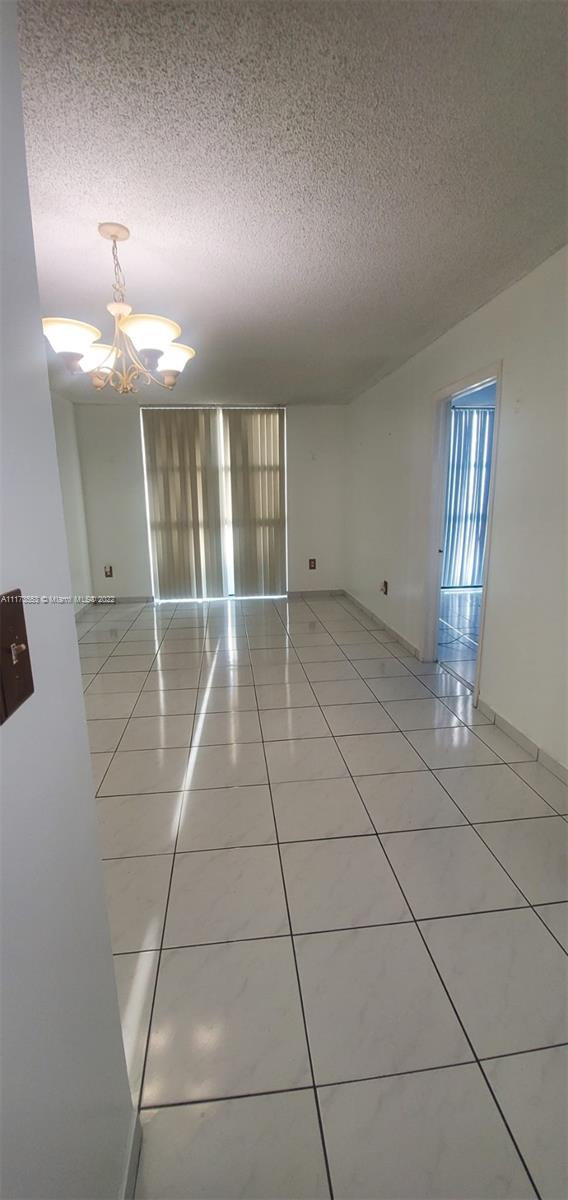 2075 Southwest 122nd Avenue, Unit 320 Miami, FL 33175 - Photo 11 of 38 a view of an empty room with stairs and chandelier