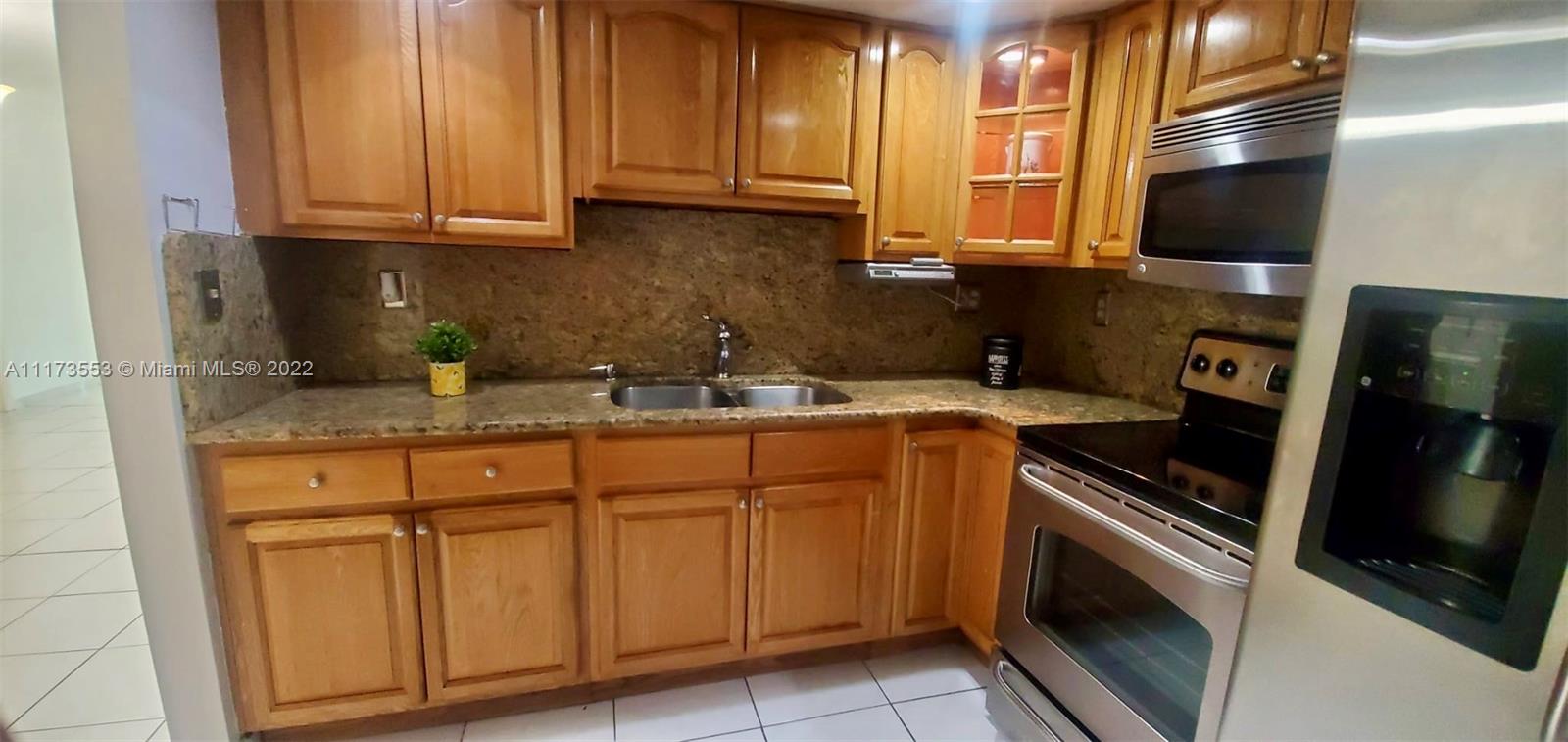 2075 Southwest 122nd Avenue, Unit 320 Miami, FL 33175 - Photo 13 of 38 a kitchen with stainless steel appliances granite countertop a sink stove and microwave