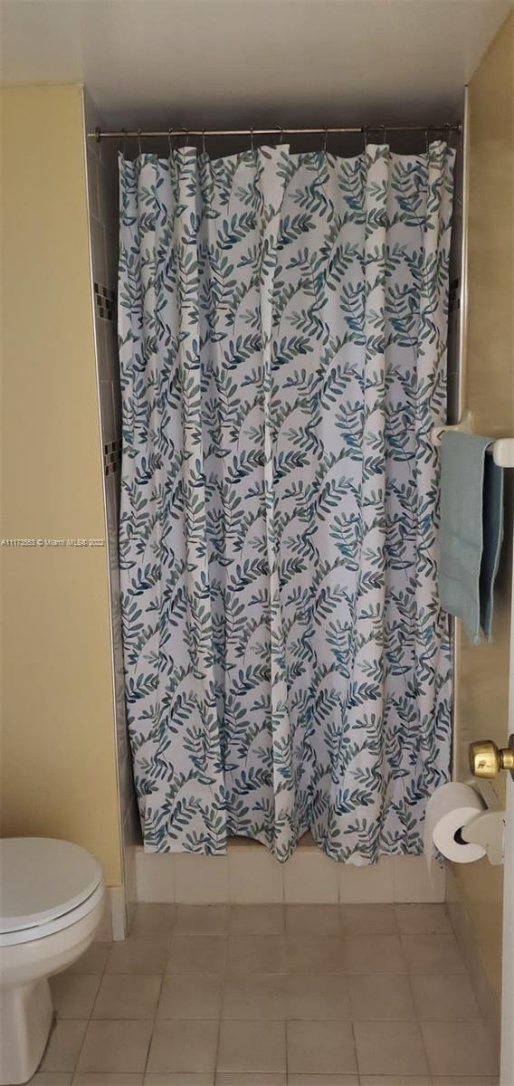 2075 Southwest 122nd Avenue, Unit 320 Miami, FL 33175 - Photo 18 of 38 a bathroom with a toilet and a shower curtain