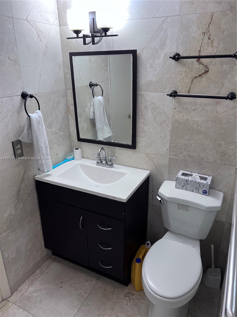 2075 Southwest 122nd Avenue, Unit 320 Miami, FL 33175 - Photo 23 of 38 a bathroom with a toilet sink and mirror