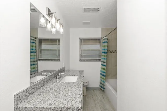 a bathroom with a granite countertop sink and a mirror