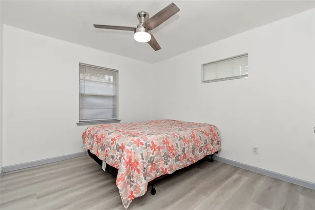 a bedroom with a bed chandelier and a window