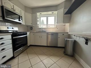 328 Hoffnagle Street, Unit 2 Philadelphia, PA 19111 - Photo 16 of 39 a kitchen with a sink a stove and cabinets