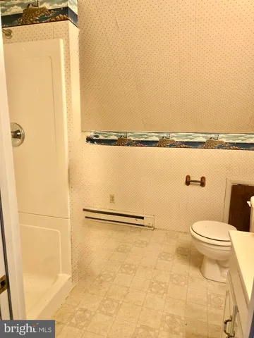 a bathroom with a toilet and a shower