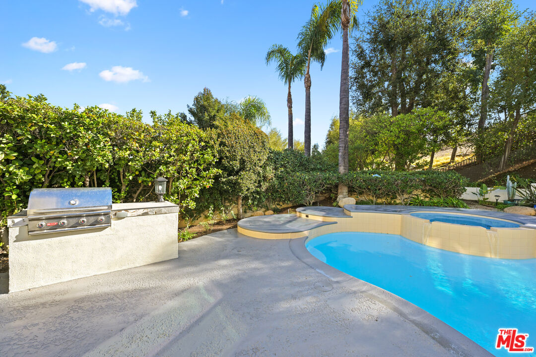 5566 Spring Hill Court Westlake Village, CA 91362 - Photo 50 of 66 a view of a swimming pool with a yard and palm trees