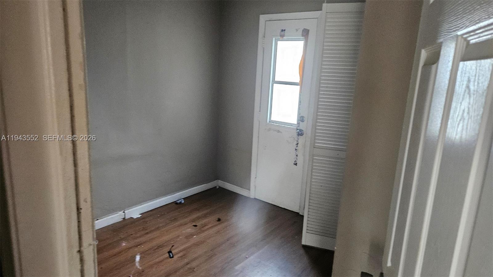 742 Southwest 10th Street Miami, FL 33130 - Photo 7 of 9 a view of an empty room with wooden floor and a window