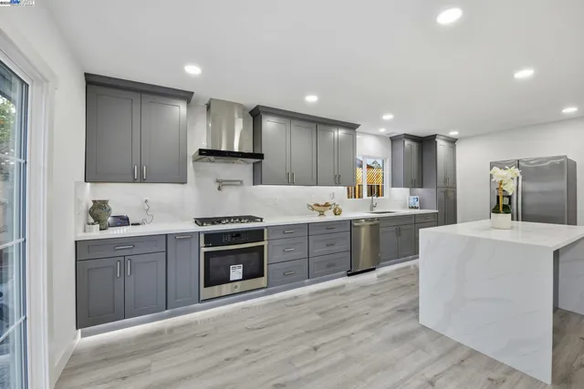 a kitchen with kitchen island sink stove and cabinets