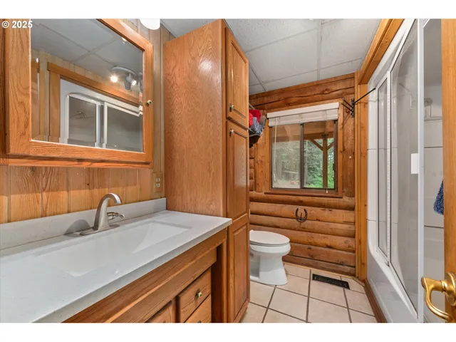 a bathroom with a sink a toilet a mirror and shower