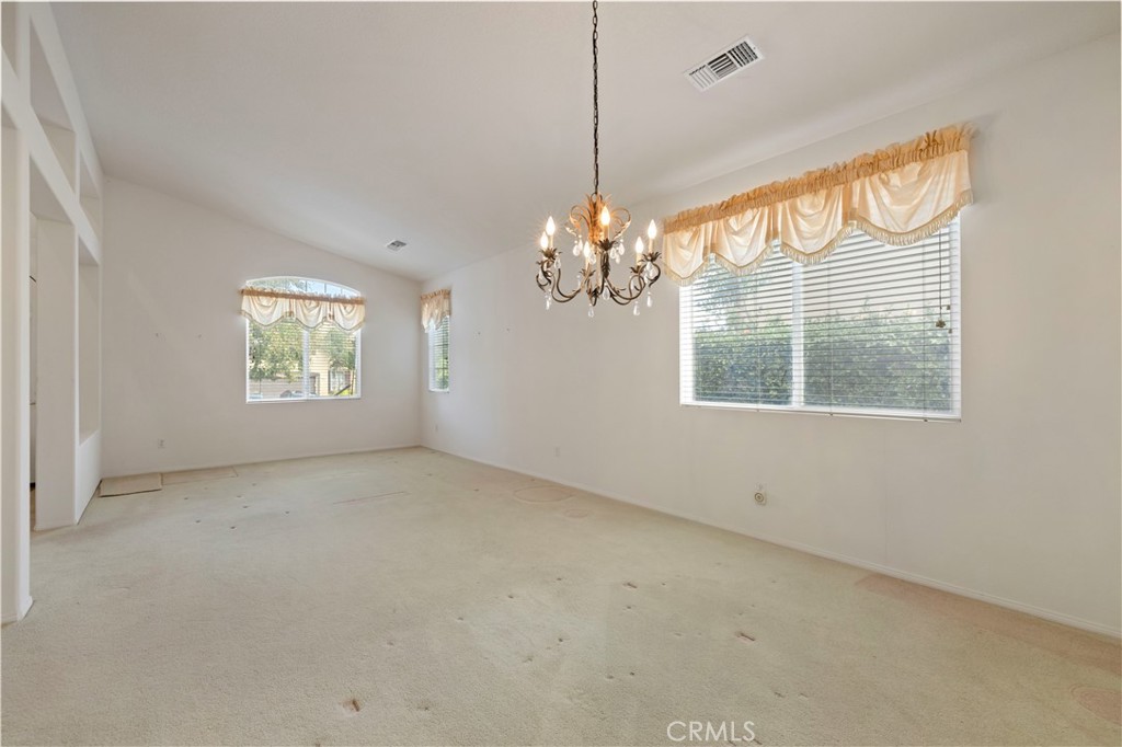 25018 Smokewood Way Stevenson Ranch, CA 91381 - Photo 15 of 71 an empty room with windows and chandelier