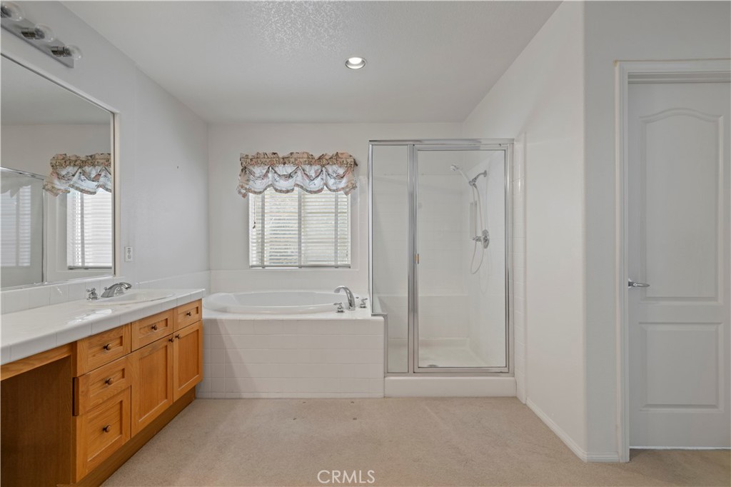 25018 Smokewood Way Stevenson Ranch, CA 91381 - Photo 32 of 71 a spacious bathroom with a double vanity sink a mirror and a bathtub