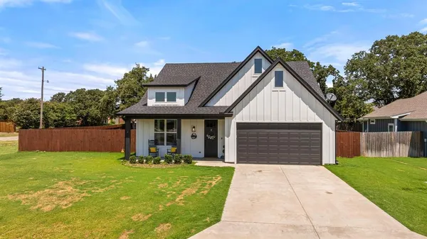 a front view of house with yard and trees in the background