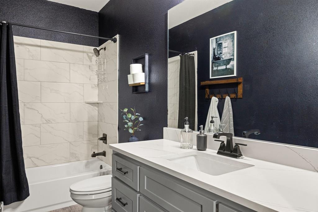 2000 Rattler Way Tolar, TX 76476 - Photo 20 of 33 a bathroom with a granite countertop sink toilet and shower