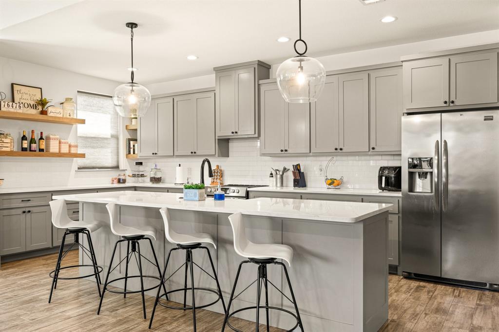 2000 Rattler Way Tolar, TX 76476 - Photo 6 of 33 a kitchen with stainless steel appliances granite countertop a sink a stove a refrigerator and island with wooden floor
