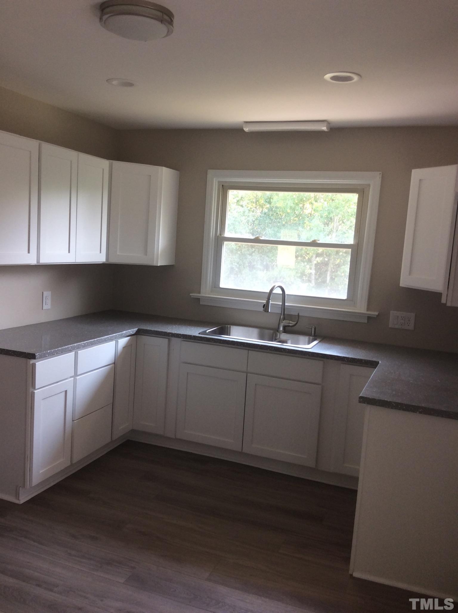 3424 Moriah Road Rougemont, NC 27572 - Photo 11 of 20 a kitchen with granite countertop white cabinets white appliances a sink and a window