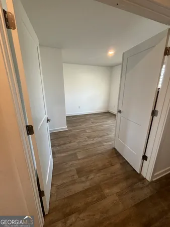 an empty room with wooden floor and staircase
