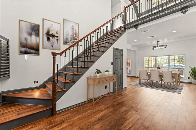 a dining room with wooden floor and stairs