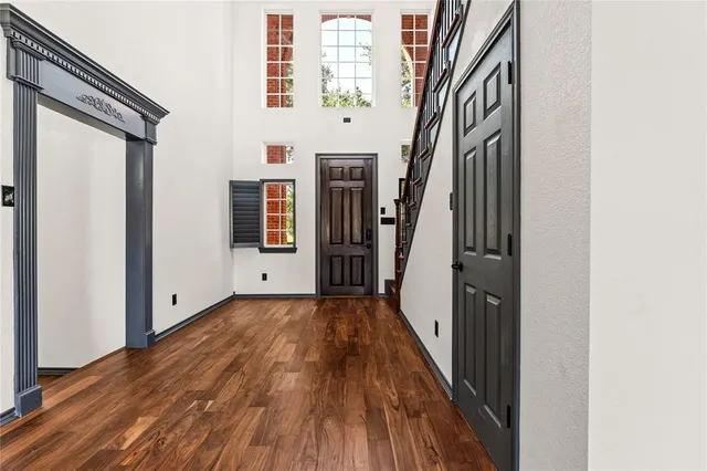 a view of a hallway with wooden floor and staircase