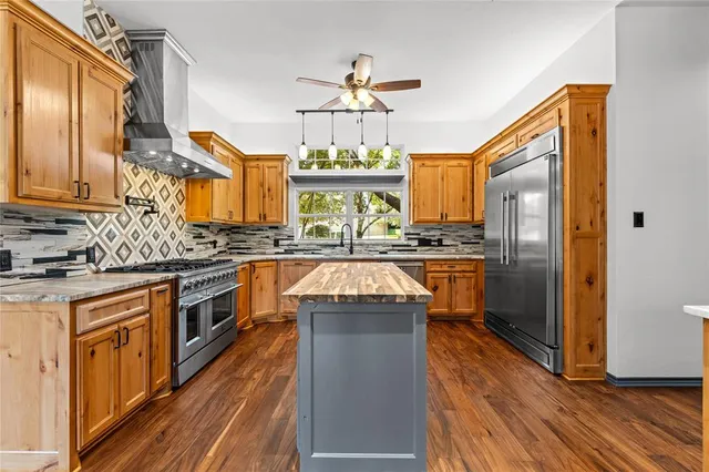 a kitchen with stainless steel appliances granite countertop a stove a sink dishwasher and a refrigerator