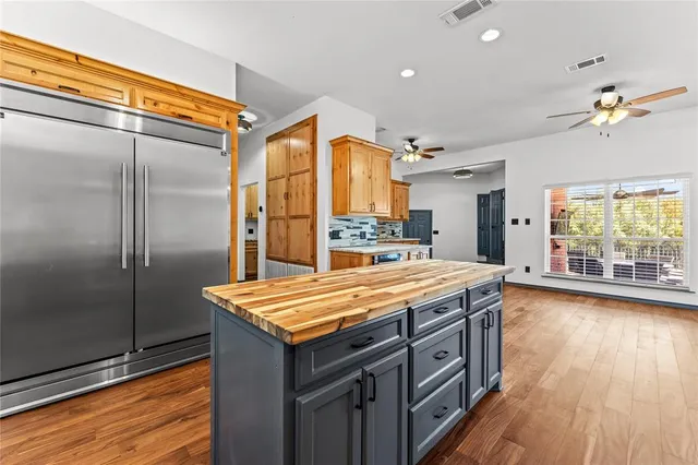 a kitchen with stainless steel appliances granite countertop a refrigerator a stove and a wooden floors